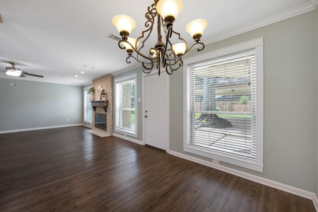 15735 Mesa Gardens Dr, Houston, TX 77095 - unfurnished dining area featuring baseboards, crown molding, a chandelier, dark wood-style floors, and a brick fireplace