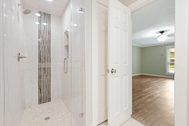 15735 Mesa Gardens Dr, Houston, TX 77095 - bathroom with a stall shower, wood finished floors, baseboards, and crown molding