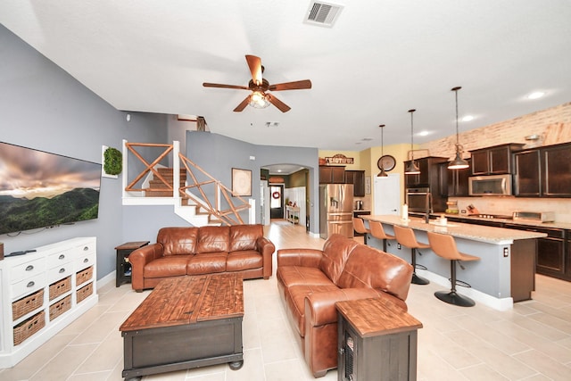5131 Kingship Ct, Katy, TX 77493 - living area with a ceiling fan, stairs, arched walkways, light tile patterned flooring, and recessed lighting