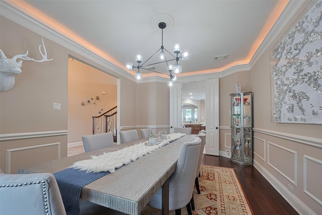 1623 Whitfield St, Sugar Land, TX 77479 - dining area with a chandelier, ornamental molding, dark wood-type flooring, wainscoting, and a decorative wall