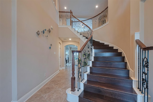 1623 Whitfield St, Sugar Land, TX 77479 - staircase featuring arched walkways, baseboards, a high ceiling, and recessed lighting