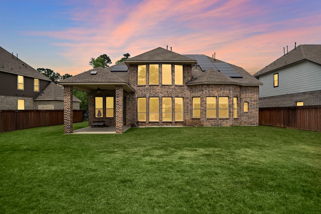 8211 Barristan Bluffs Ct, Magnolia, TX 77354 - back of property featuring brick siding, a patio area, solar panels, and a shingled roof