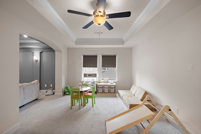 8211 Barristan Bluffs Ct, Magnolia, TX 77354 - sitting room featuring a tray ceiling, carpet floors, arched walkways, ceiling fan, and baseboards