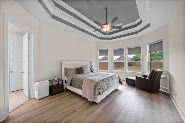8211 Barristan Bluffs Ct, Magnolia, TX 77354 - bedroom featuring a raised ceiling, wood finished floors, baseboards, a ceiling fan, and crown molding