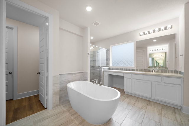 8211 Barristan Bluffs Ct, Magnolia, TX 77354 - full bath with a shower stall, vanity, a freestanding tub, recessed lighting, and tile walls