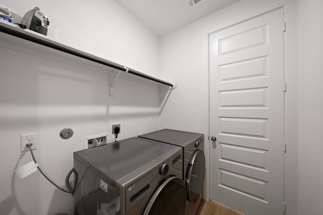 8211 Barristan Bluffs Ct, Magnolia, TX 77354 - laundry room with washing machine and clothes dryer and light wood-style flooring