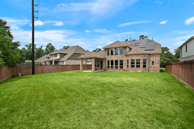 8211 Barristan Bluffs Ct, Magnolia, TX 77354 - back of property featuring solar panels, a patio area, brick siding, and a shingled roof