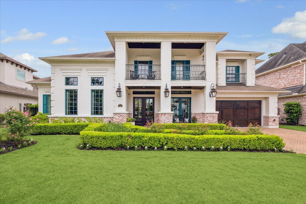 23 E Loftwood Cir, Spring, TX 77382 - greek revival house featuring a balcony, french doors, a front yard, and brick siding