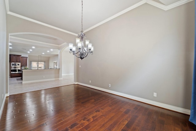 19403 Shady Edge Dr, Cypress, TX 77433 - unfurnished room with a chandelier, arched walkways, wood finished floors, baseboards, and ornamental molding