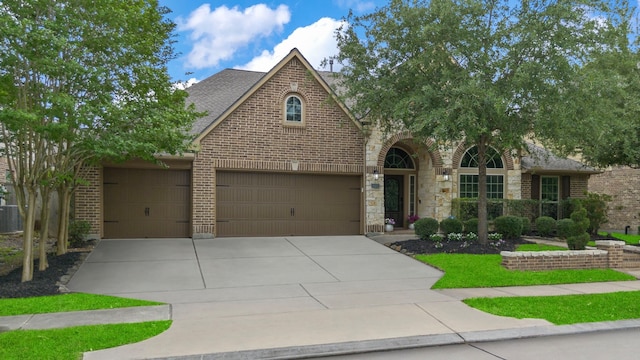 19403 Shady Edge Dr, Cypress, TX 77433 - view of front facade featuring brick siding, concrete driveway, central AC, roof with shingles, and an attached garage