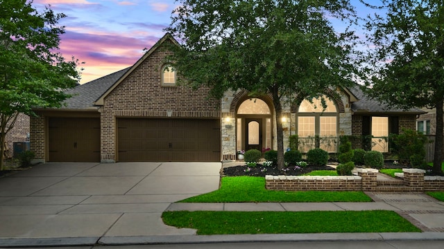 19403 Shady Edge Dr, Cypress, TX 77433 - view of front of home with concrete driveway, brick siding, roof with shingles, and a garage