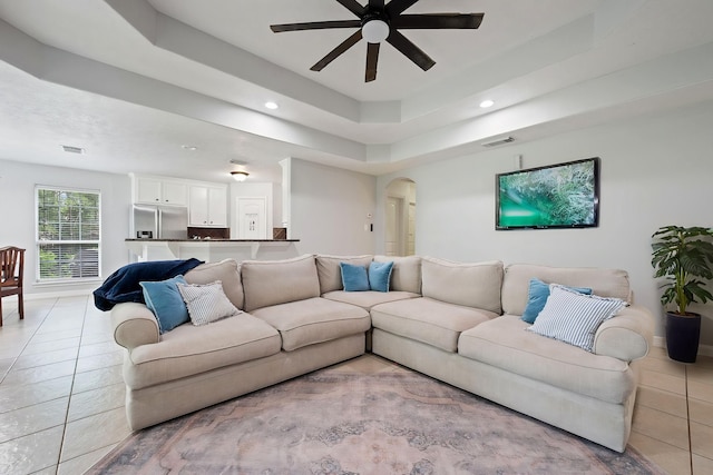 402 Eastwood Dr, Woodbranch, TX 77357 - living area with arched walkways, ceiling fan, recessed lighting, light tile patterned floors, and a tray ceiling