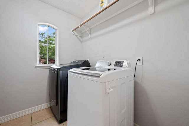 402 Eastwood Dr, Woodbranch, TX 77357 - laundry room with washer and dryer, light tile patterned flooring, and baseboards