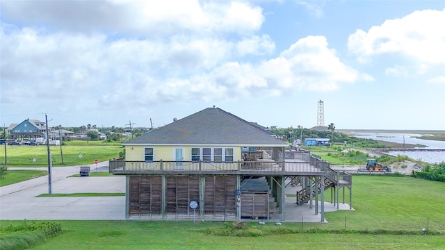 1508 Galveston Ave, Port Bolivar, TX 77650 - rear view of house featuring stairs, a deck with water view, a yard, driveway, and a patio