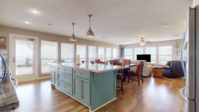 1508 Galveston Ave, Port Bolivar, TX 77650 - kitchen featuring freestanding refrigerator, a kitchen breakfast bar, light wood-style floors, light countertops, and recessed lighting
