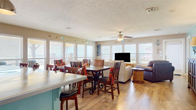 1508 Galveston Ave, Port Bolivar, TX 77650 - dining space with a textured ceiling, a ceiling fan, and light wood-style flooring