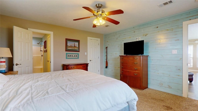 1508 Galveston Ave, Port Bolivar, TX 77650 - bedroom with wood walls, carpet flooring, a ceiling fan, and ensuite bath