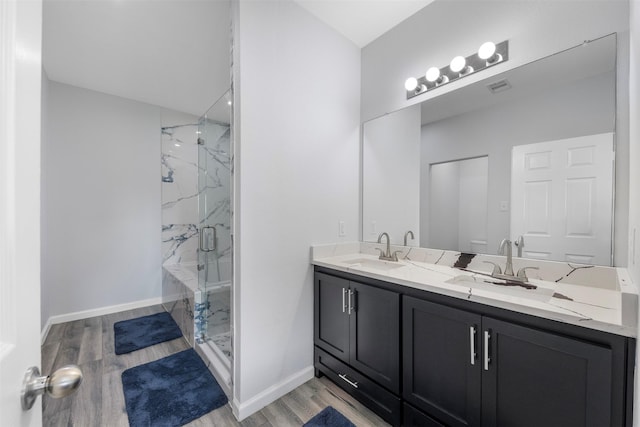 6902 White Ash Ln, Baytown, TX 77521 - bathroom featuring a marble finish shower, wood finished floors, double vanity, and baseboards