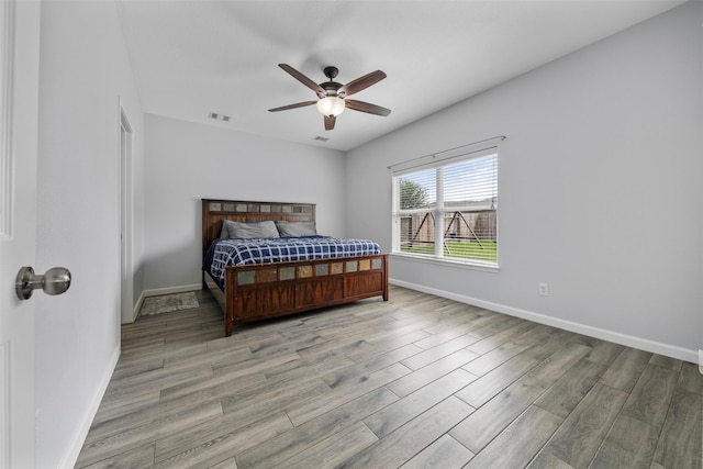 6902 White Ash Ln, Baytown, TX 77521 - bedroom featuring baseboards, light wood-type flooring, and a ceiling fan