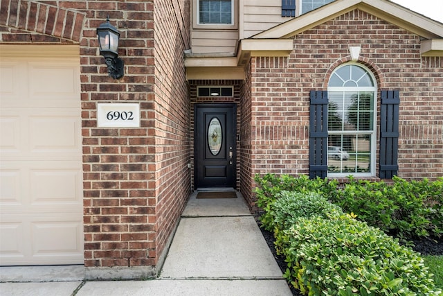 6902 White Ash Ln, Baytown, TX 77521 - view of exterior entry featuring brick siding and an attached garage