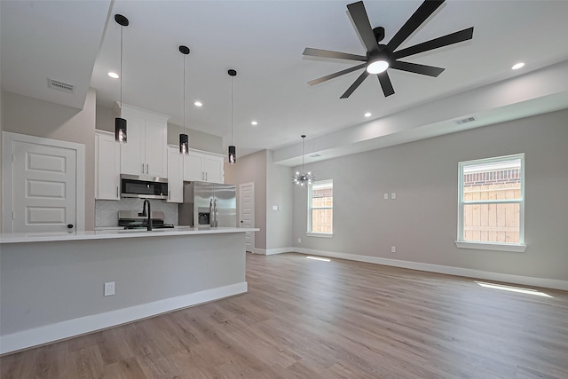 7911 Carver Rd, Houston, TX 77088 - kitchen with appliances with stainless steel finishes, light countertops, backsplash, white cabinets, and light wood-style flooring