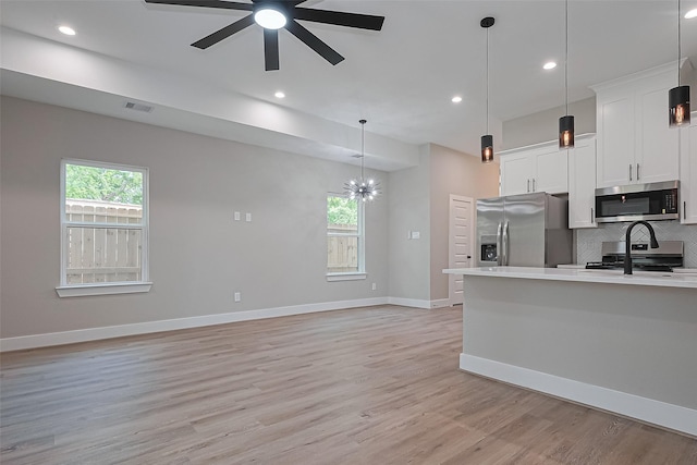 7911 Carver Rd, Houston, TX 77088 - kitchen with stainless steel appliances, light countertops, backsplash, ceiling fan, and white cabinetry