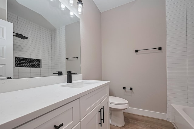 7911 Carver Rd, Houston, TX 77088 - full bathroom featuring wood finished floors, vanity, toilet, baseboards, and washtub / shower combination
