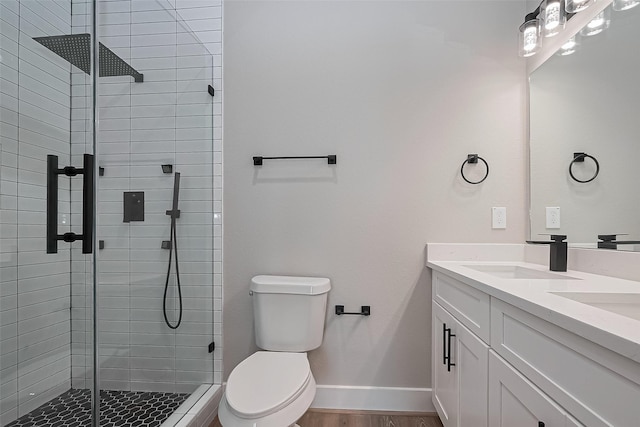 7911 Carver Rd, Houston, TX 77088 - full bathroom with double vanity, toilet, a stall shower, baseboards, and wood finished floors
