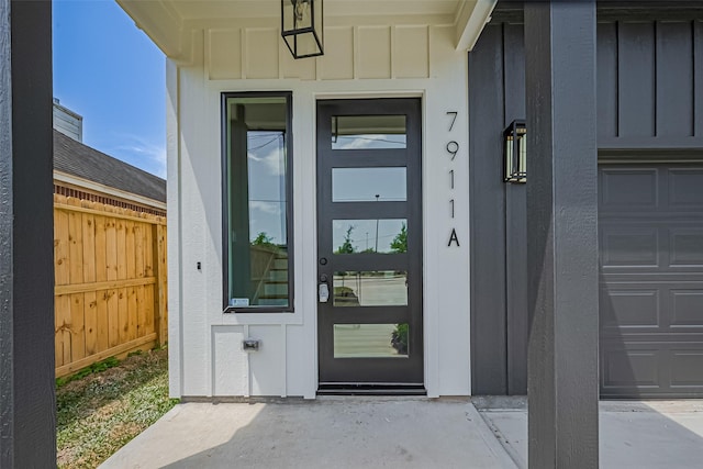 7911 Carver Rd, Houston, TX 77088 - view of exterior entry with board and batten siding and a garage