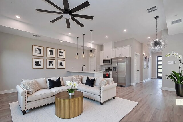 7911 Carver Rd, Houston, TX 77088 - living room with light wood-style flooring, a ceiling fan, recessed lighting, and a chandelier