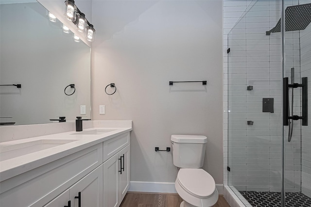 7911 Carver Rd, Houston, TX 77088 - bathroom featuring double vanity, a stall shower, wood finished floors, toilet, and baseboards