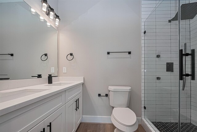 7911 Carver Rd, Houston, TX 77088 - bathroom featuring double vanity, a stall shower, and wood finished floors