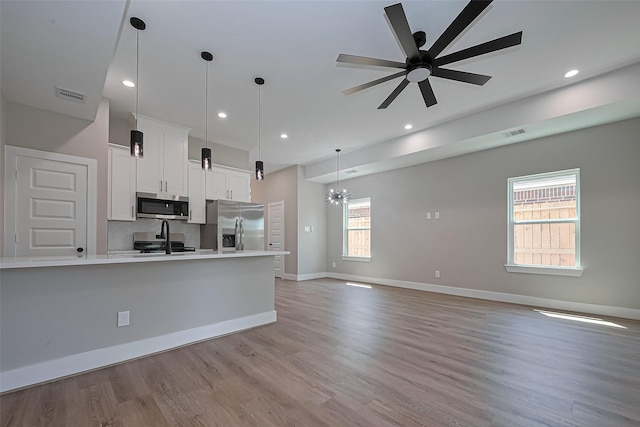 7911 Carver Rd, Houston, TX 77088 - kitchen with stainless steel appliances, white cabinetry, ceiling fan, light countertops, and light wood-type flooring