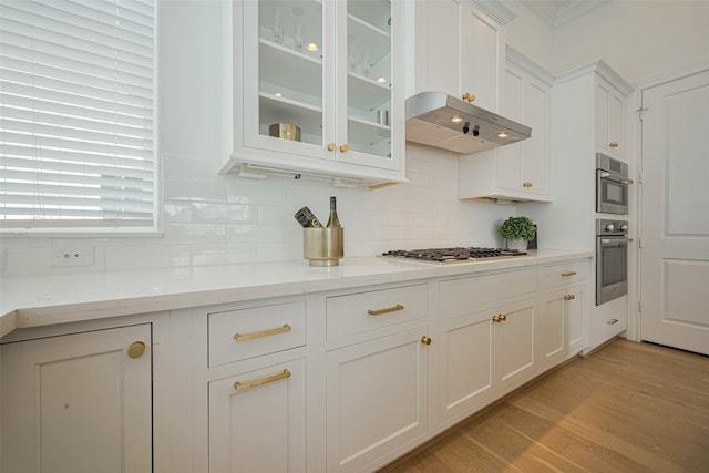 1205 Timbergrove Acres St, Houston, TX 77008 - kitchen with white cabinets, stainless steel appliances, backsplash, glass insert cabinets, and wall chimney exhaust hood