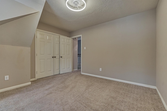 94 S Magnolia Pond Pl, The Woodlands, TX 77381 - unfurnished bedroom featuring carpet, a textured ceiling, baseboards, and a closet