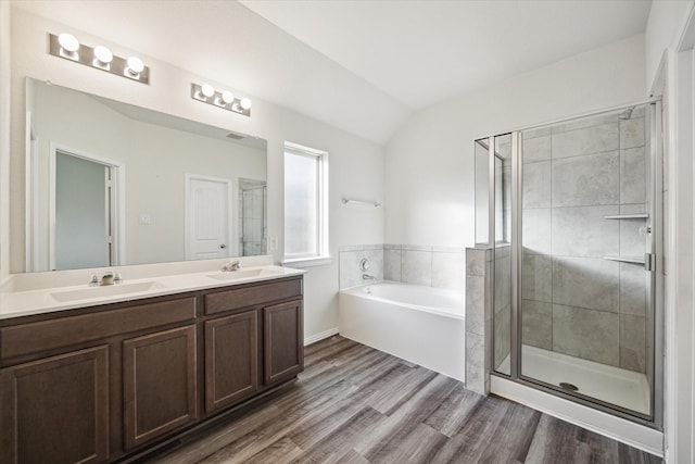 8931 Beacon Mill Dr, Cypress, TX 77433 - bathroom with double vanity, a bath, lofted ceiling, a shower stall, and wood finished floors