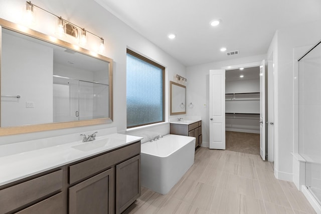 19209 Olive Heath Ln, Magnolia, TX 77355 - bathroom with a stall shower, two vanities, recessed lighting, a tub to relax in, and a spacious closet