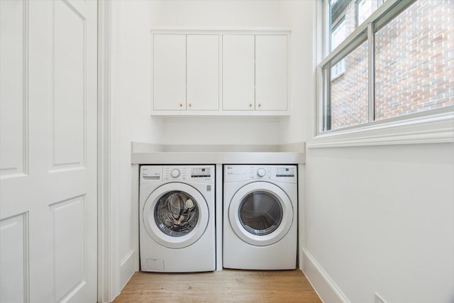 2013 Persa St, Houston, TX 77019 - laundry room featuring washer and dryer, cabinet space, and light wood-style flooring