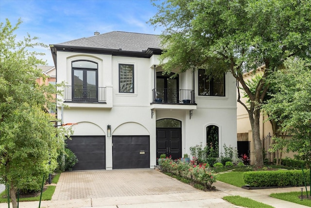 2013 Persa St, Houston, TX 77019 - french provincial home featuring a balcony, a garage, and stucco siding