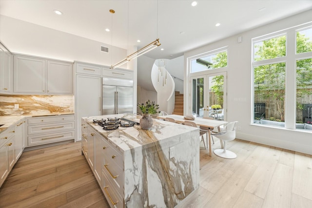 2013 Persa St, Houston, TX 77019 - kitchen featuring built in refrigerator, light wood-style floors, light stone counters, recessed lighting, and a kitchen island