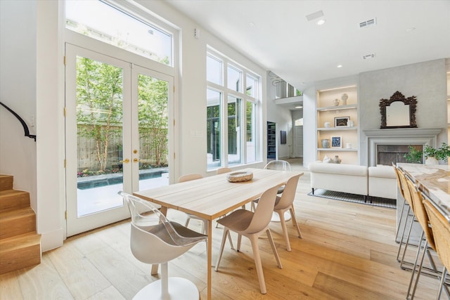 2013 Persa St, Houston, TX 77019 - dining area with light wood-style floors, built in shelves, a fireplace, french doors, and recessed lighting