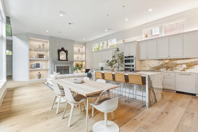 2013 Persa St, Houston, TX 77019 - dining space with light wood-style flooring, built in features, a fireplace, and recessed lighting