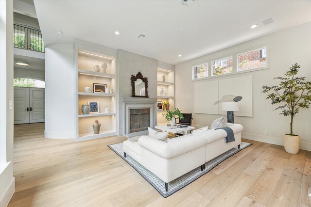 2013 Persa St, Houston, TX 77019 - living area featuring a fireplace, wood finished floors, baseboards, built in shelves, and recessed lighting