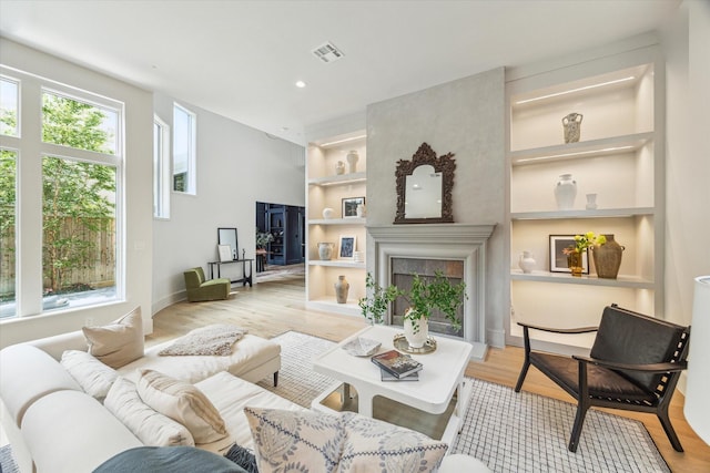 2013 Persa St, Houston, TX 77019 - living area featuring built in shelves, light wood-style floors, a fireplace, recessed lighting, and baseboards