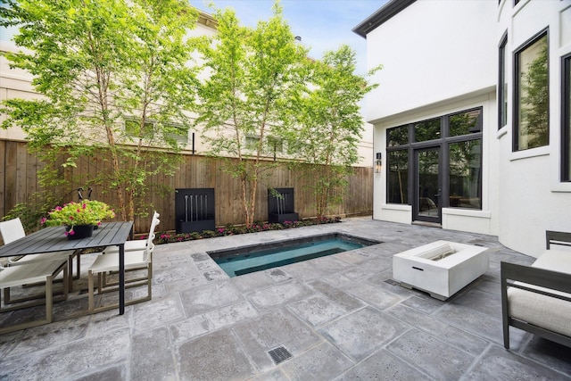 2013 Persa St, Houston, TX 77019 - fenced backyard featuring a patio, an in-ground hot tub, a fire pit, and outdoor dining area