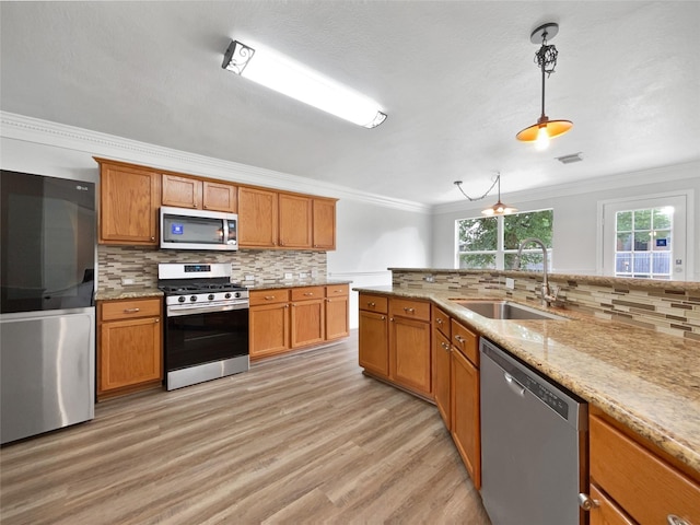 426 N Lindbergh Ct, Baytown, TX 77521 - kitchen featuring appliances with stainless steel finishes, a sink, decorative backsplash, ornamental molding, and light wood-type flooring