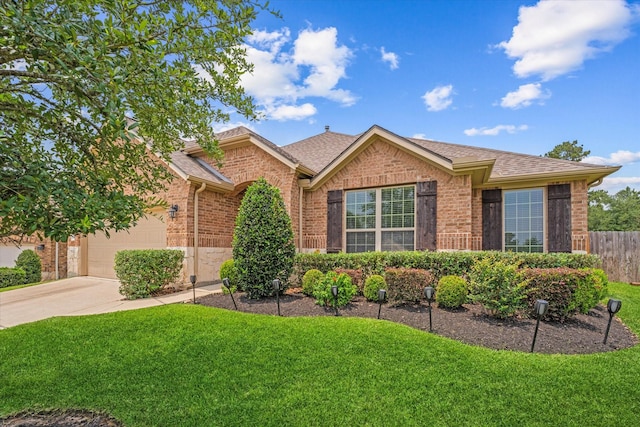 12103 Kaiso Ln, Conroe, TX 77304 - view of front of home featuring brick siding, concrete driveway, an attached garage, and a shingled roof