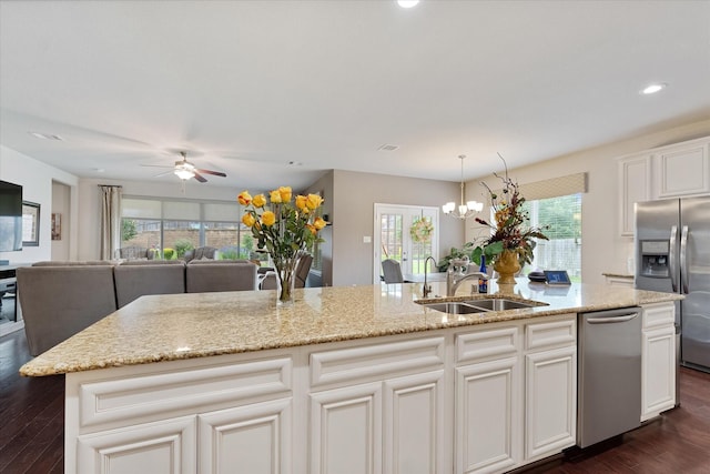 12103 Kaiso Ln, Conroe, TX 77304 - kitchen featuring stainless steel appliances, a sink, dark wood-type flooring, open floor plan, and ceiling fan