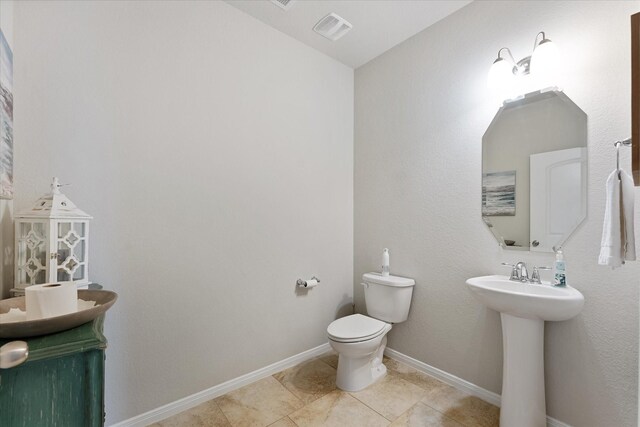 12103 Kaiso Ln, Conroe, TX 77304 - bathroom with toilet, a sink, tile patterned floors, and baseboards