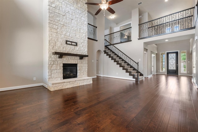 15002 House Martin Ln, Cypress, TX 77429 - unfurnished living room with ceiling fan, stairs, hardwood / wood-style floors, a stone fireplace, and baseboards